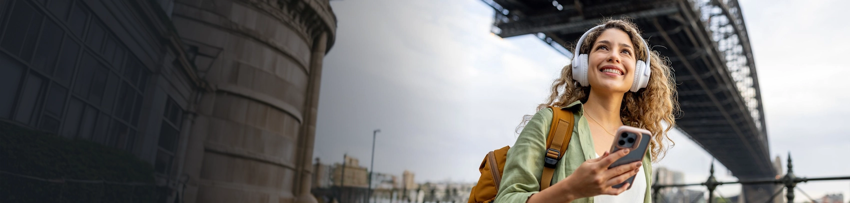 Mujer con celular y audifonos en la ciudad